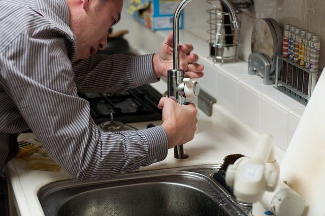 A plumber fixing the sink, the best way to avoid dangers of DIY plumbing projects.