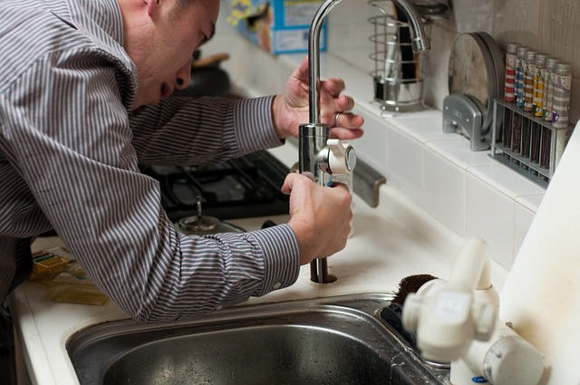 A plumber fixing a low-pressure faucet, one of the hidden signs that something is not right with your plumbing.