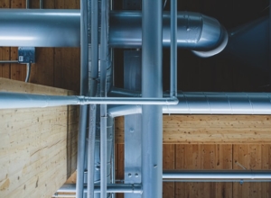Gray pipes running alongside wooden beams.
