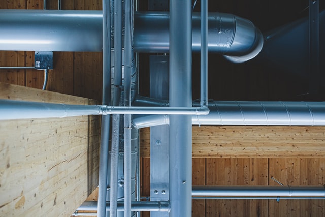 Gray pipes running alongside wooden beams.