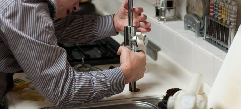 repairman fixing a sink