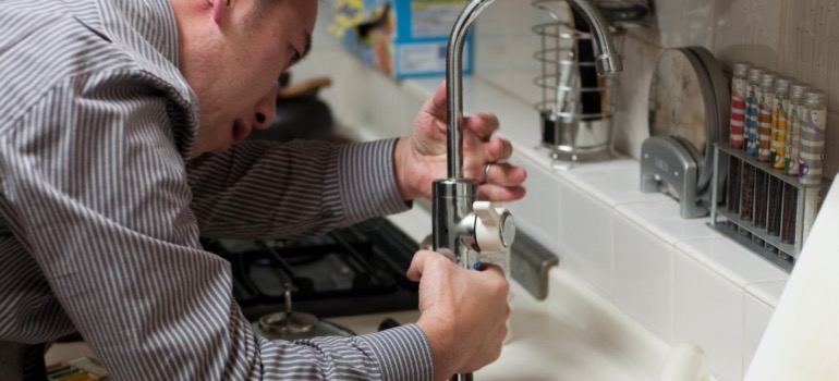 A plumber inspecting the sink