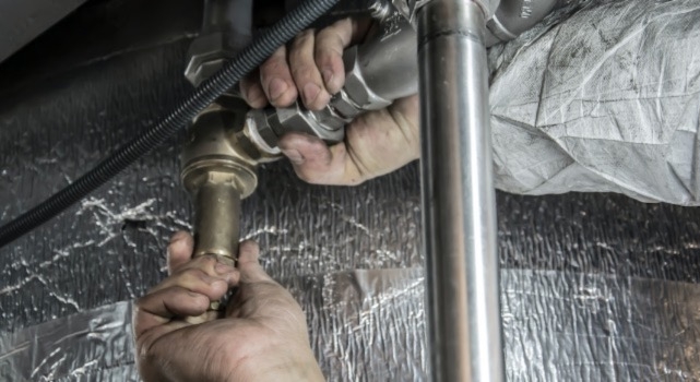 A plumber working on someone’s home plumbing system