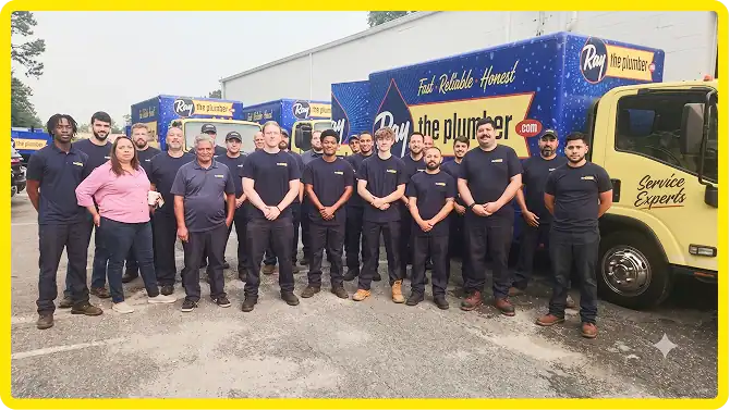 A group of plumbers in uniform stands in front of two branded Ray the Plumber trucks in a parking lot.